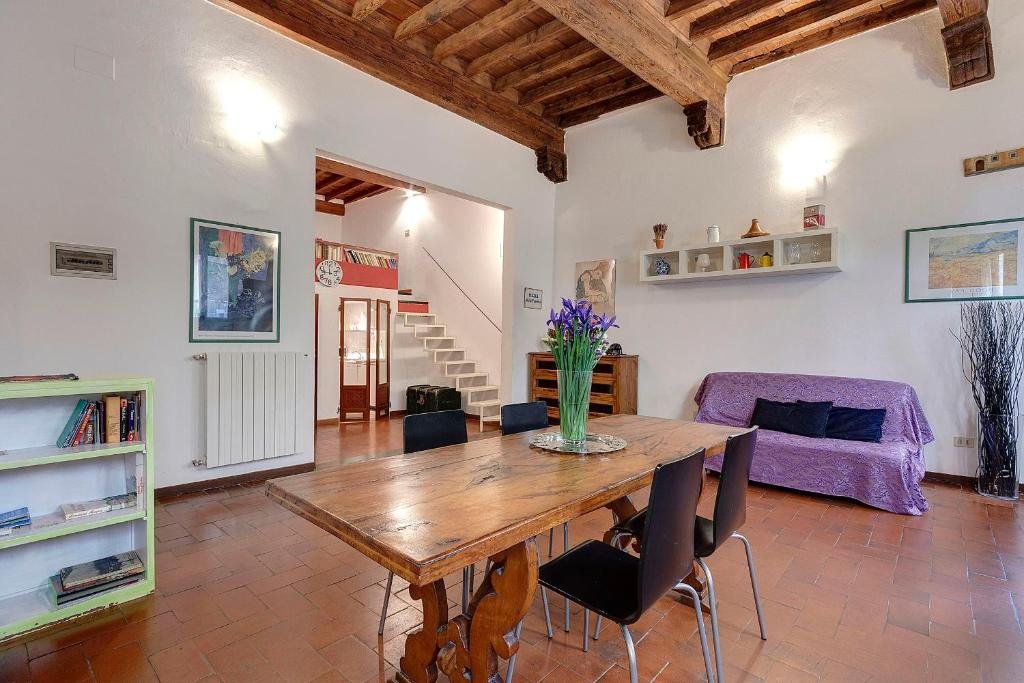 Sala luminosa con tavolo in legno e travi a vista
