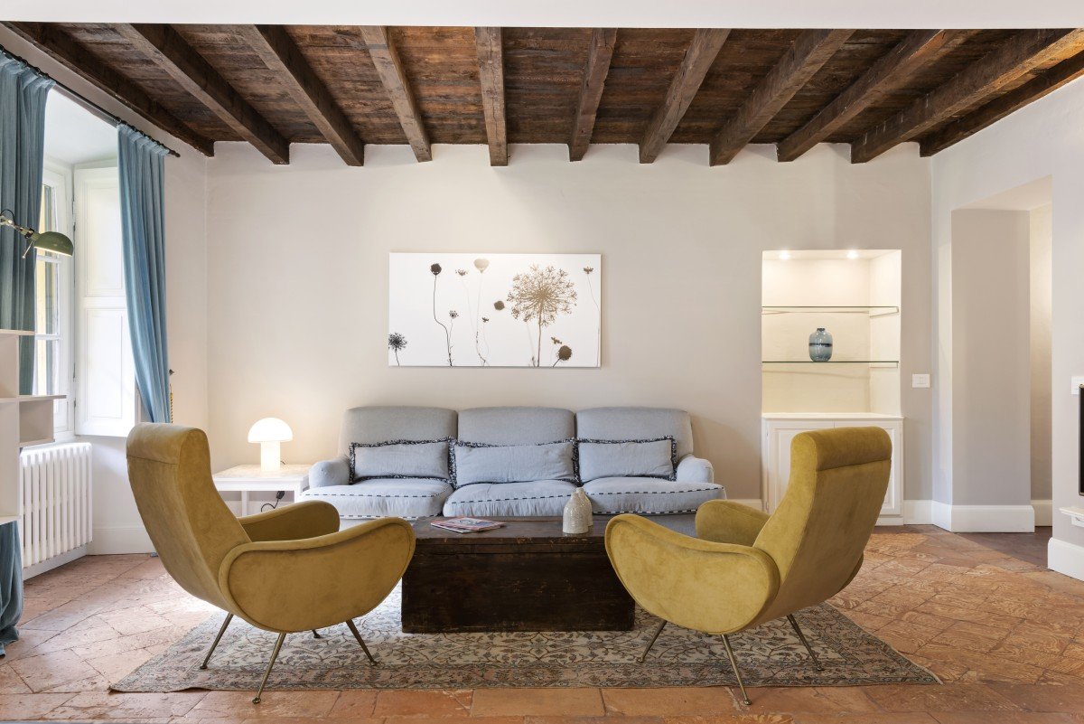 Salotto elegante con poltrone gialle e travi in legno